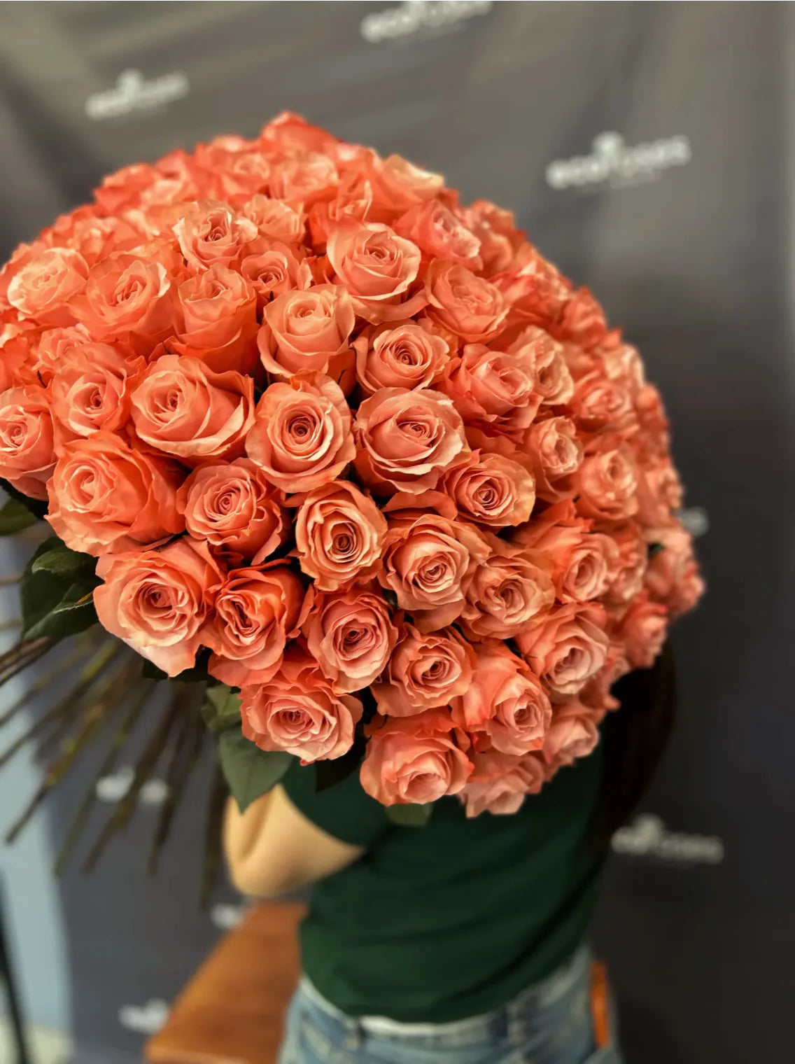 Man carrying a large bouquet of Apricot Delight roses, showcasing the vibrant and lush hues of the blooms-Flower Shops In Glendale California