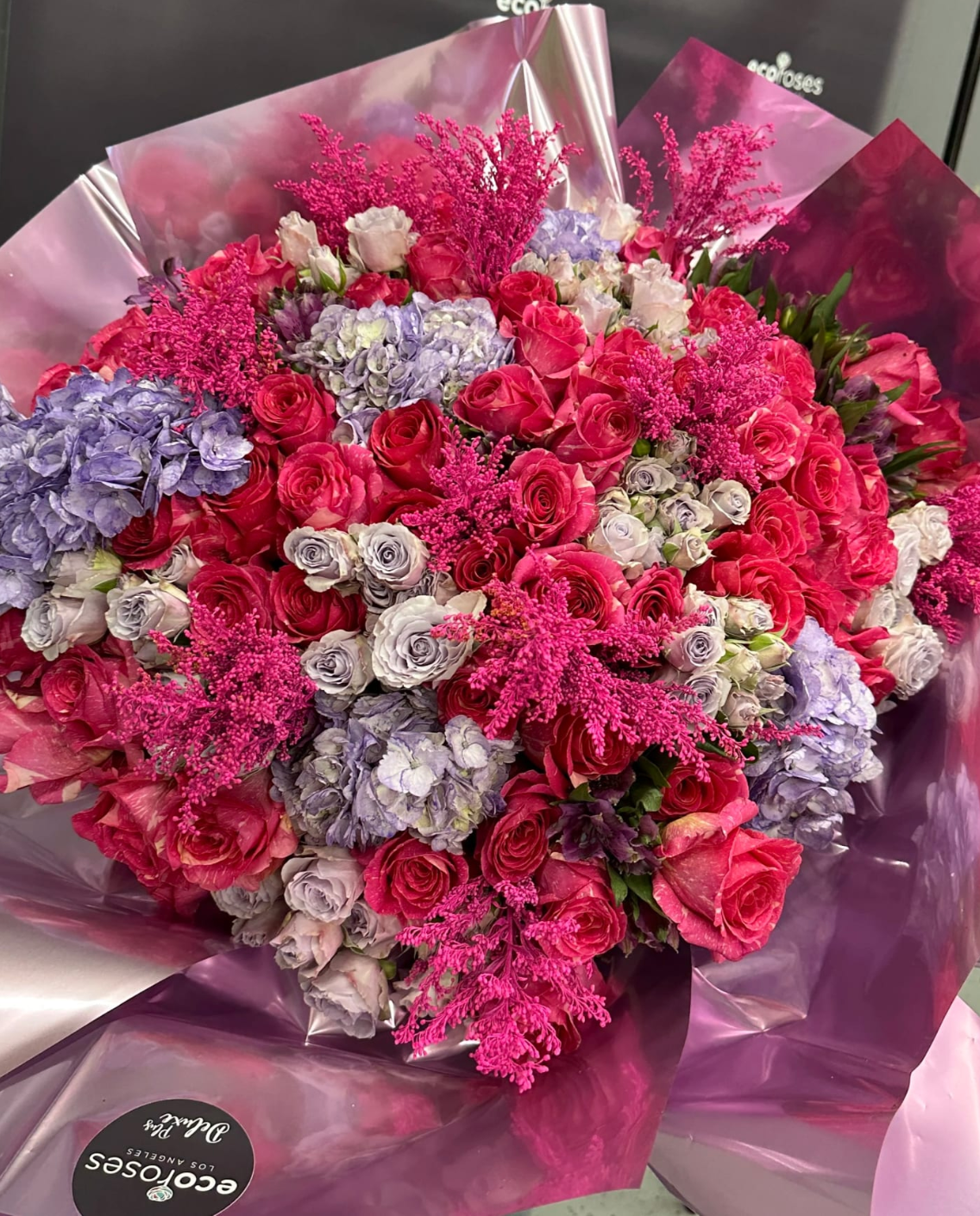  Bubblegum Beauty deluxe bouquet features hot pink and purple blooms, adding a pop of color and fun to your special event. 